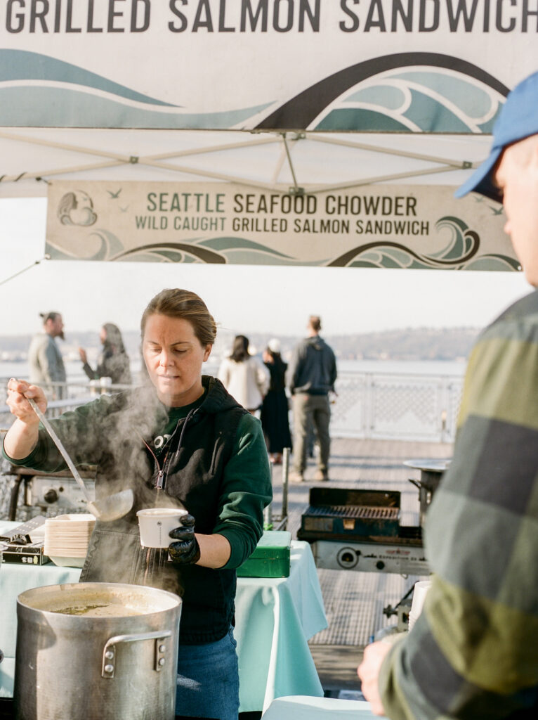 Pacific North West Travel Photography Photo of Seattle Seafood Chowder employee serving a cup of chowder